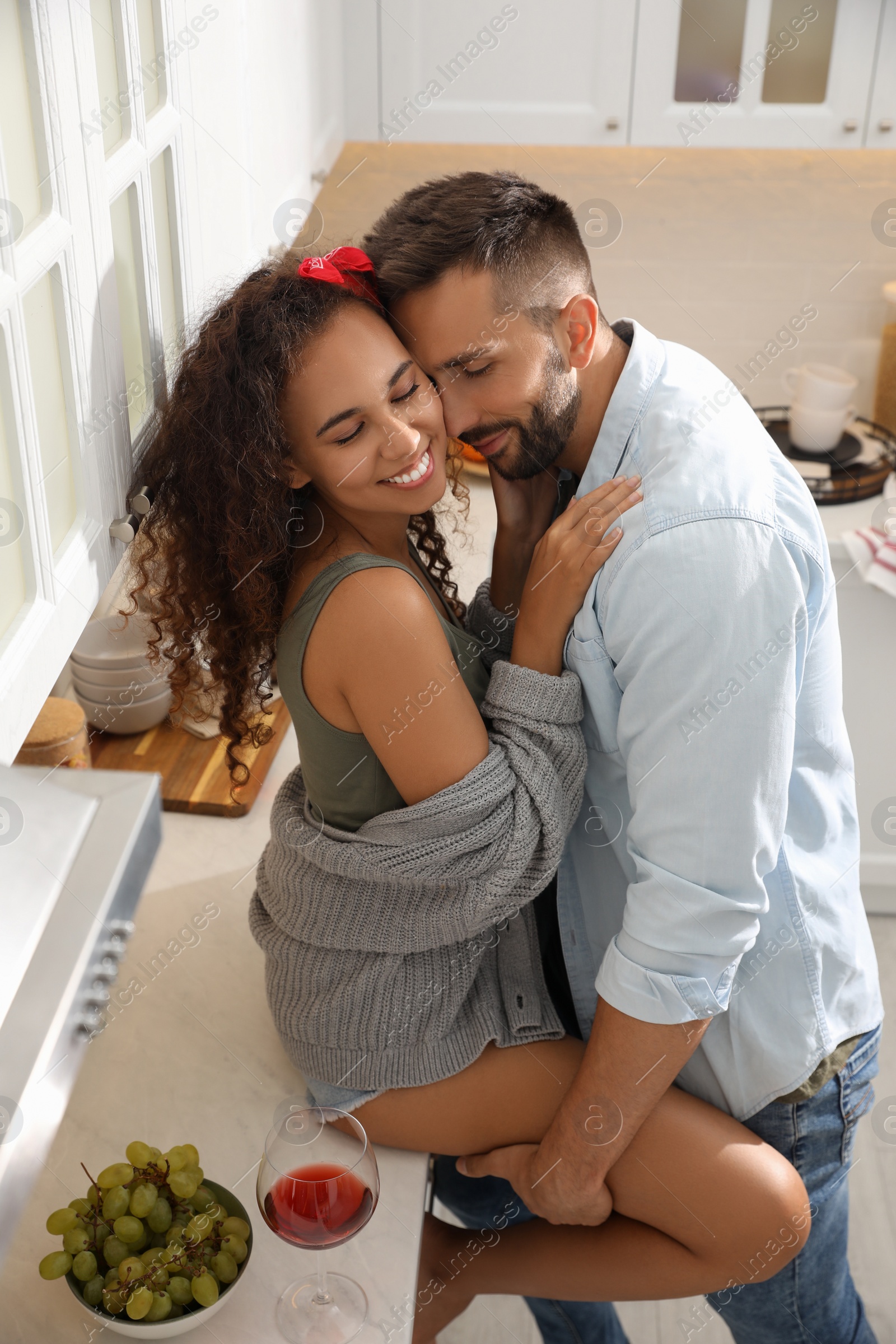 Photo of Lovely couple enjoying time together during romantic dinner in kitchen