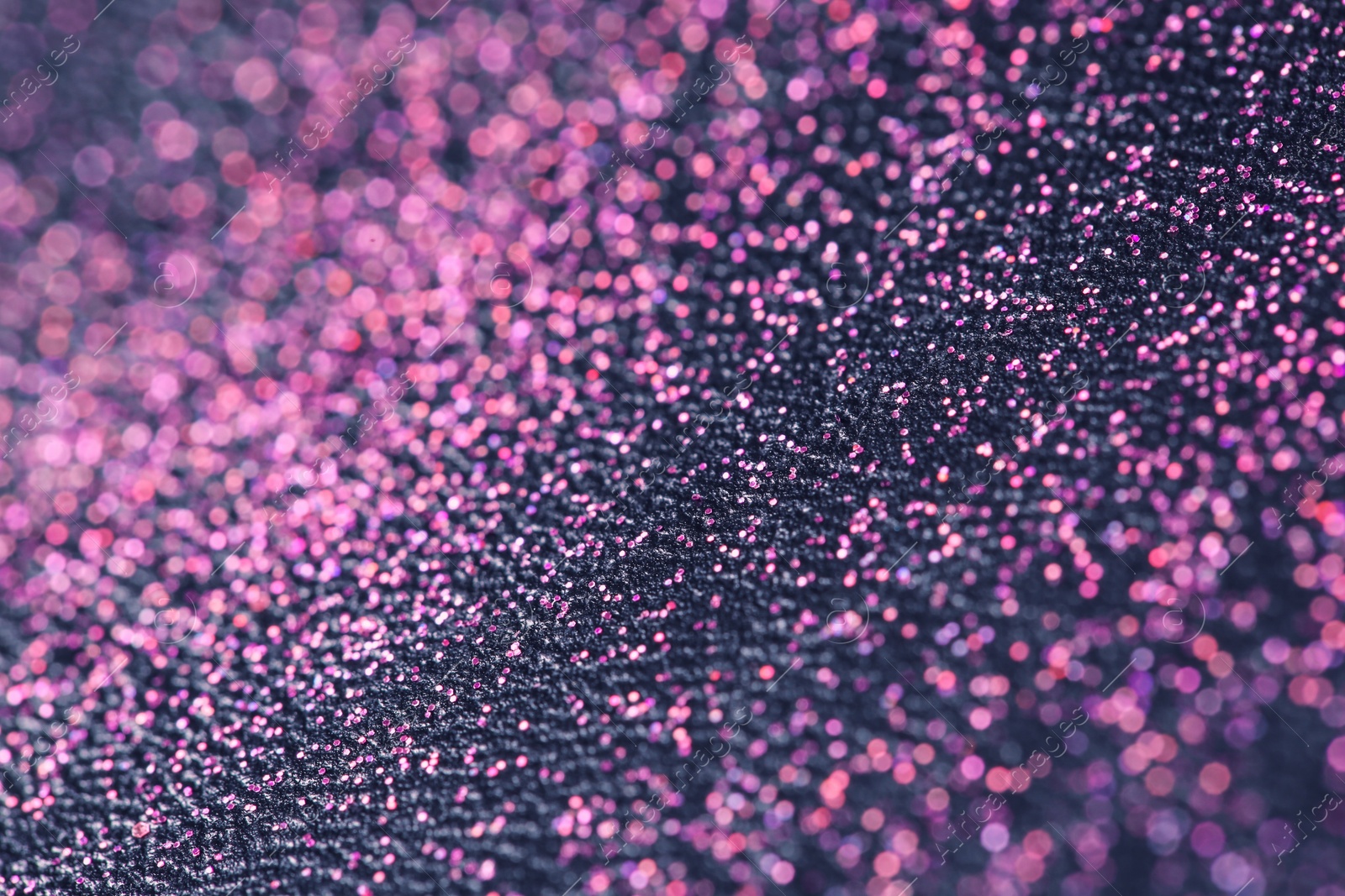 Photo of Pink glitter with bokeh effect on dark background