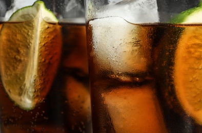 Photo of Glasses of refreshing soda drinks with ice cubes and lime, closeup