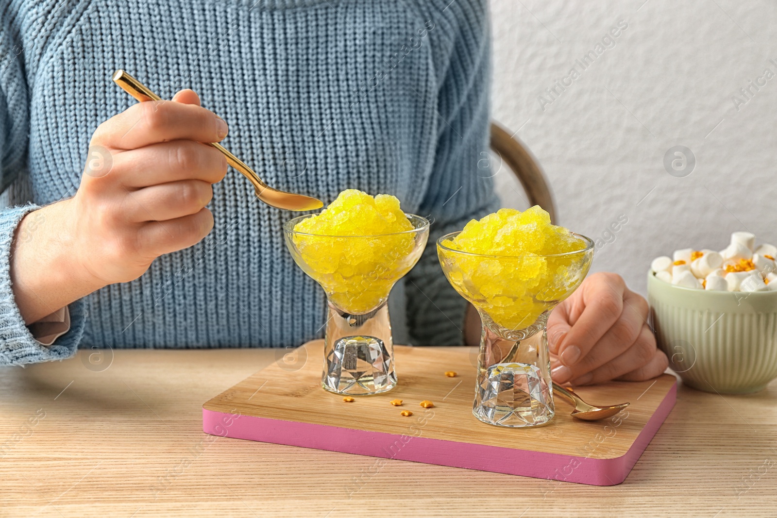 Photo of Woman eating tasty snow ice cream dessert at table, closeup