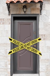 Yellow crime scene tape blocking entrance to house