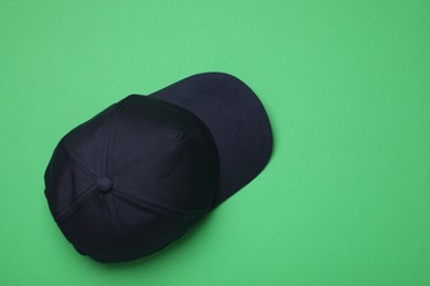 Photo of Baseball cap on green background, top view. Space for text