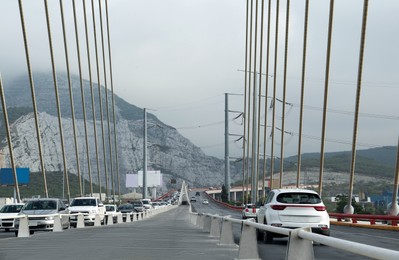 View of cars on modern bridge near mountain