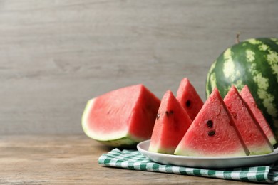 Photo of Delicious fresh watermelon slices on wooden table. Space for text