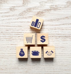 Cubes with different icons on wooden background, top view