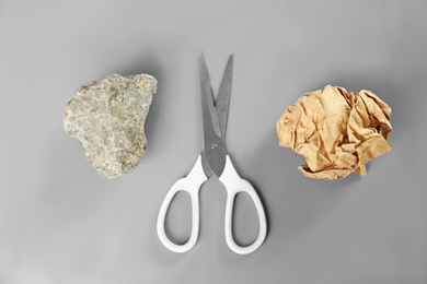 Flat lay composition with rock, paper and scissors on grey background