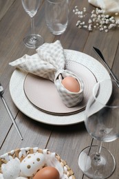 Photo of Festive table setting with bunny ears made of egg and napkin. Easter celebration