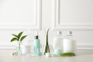 Natural ingredients for cosmetic products and laboratory glassware on white table