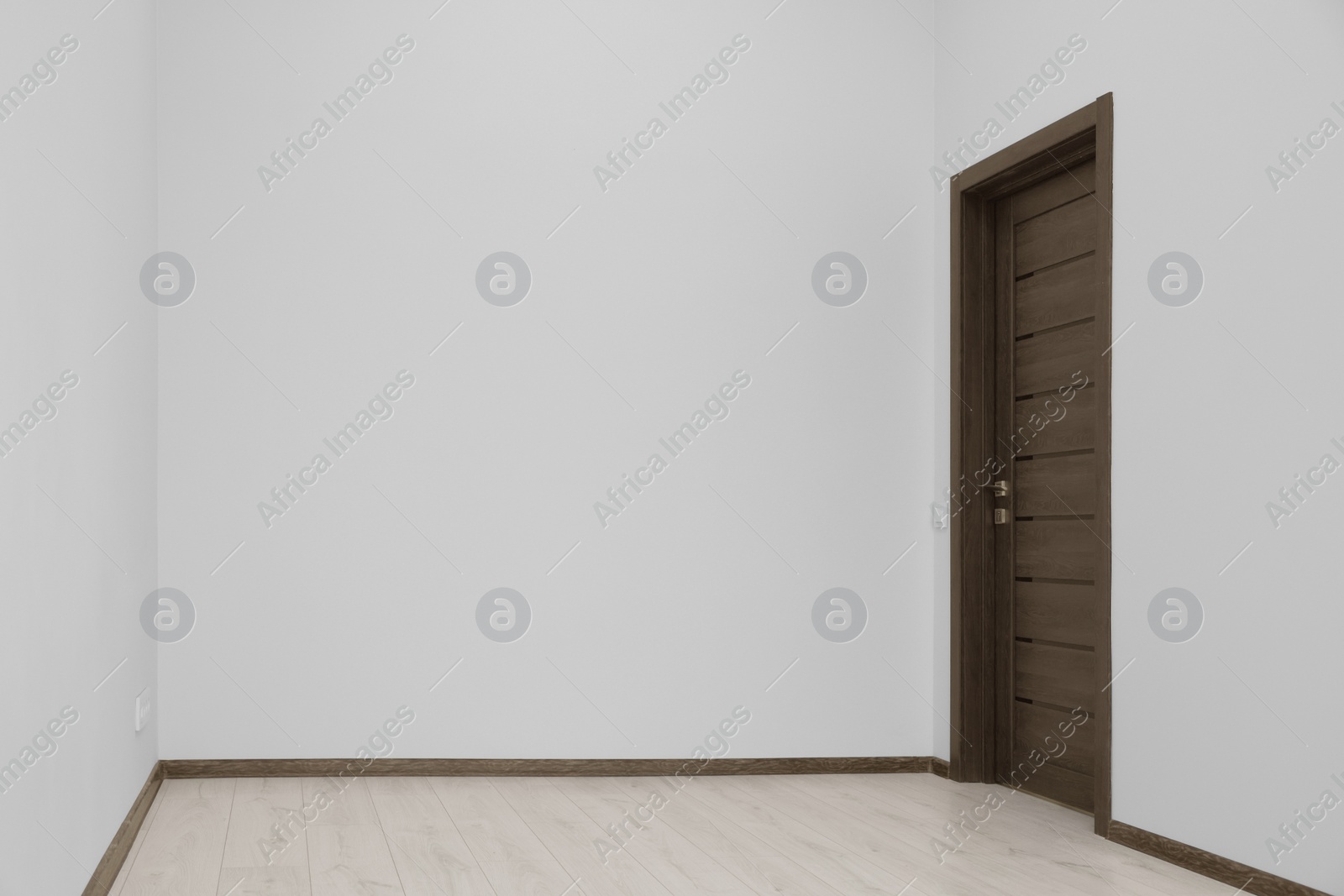 Photo of Empty renovated room with white walls and black door