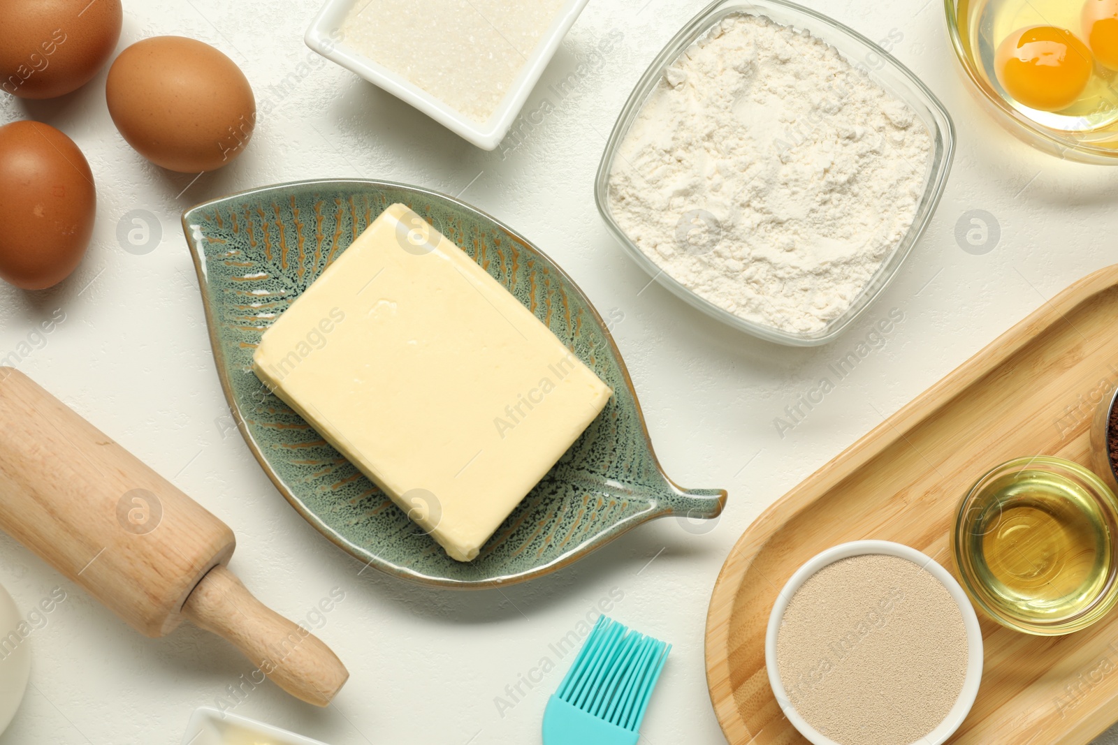 Photo of Flat lay composition with fresh butter among other products on white table