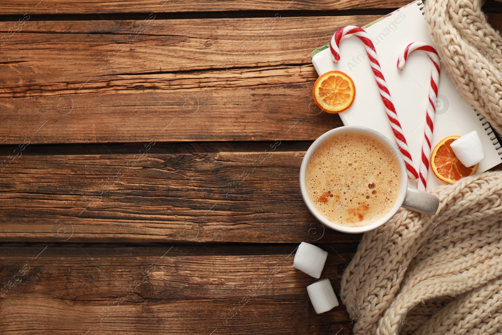 Photo of Flat lay composition with cup of coffee and sweets on wooden table, space for text. Cozy winter