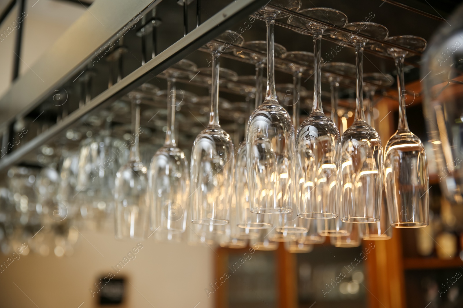 Photo of Many clean glasses on metal rack in restaurant