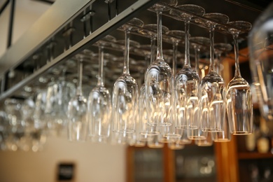 Photo of Many clean glasses on metal rack in restaurant
