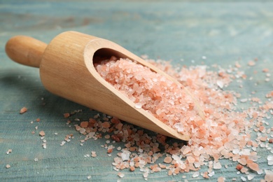Photo of Scoop and pink himalayan salt on light blue wooden table, closeup