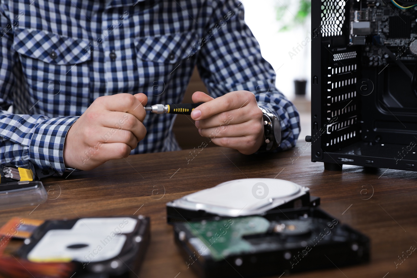 Photo of Male technician repairing computer at table, closeup