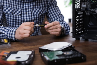 Male technician repairing computer at table, closeup