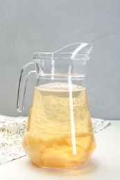Photo of Delicious quince drink in glass jug on white table