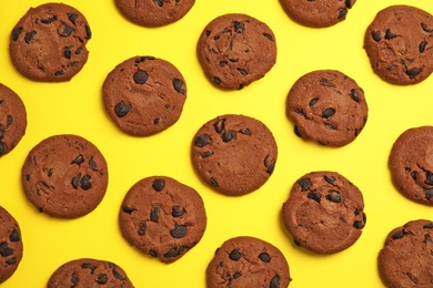 Delicious chocolate chip cookies on color background, flat lay