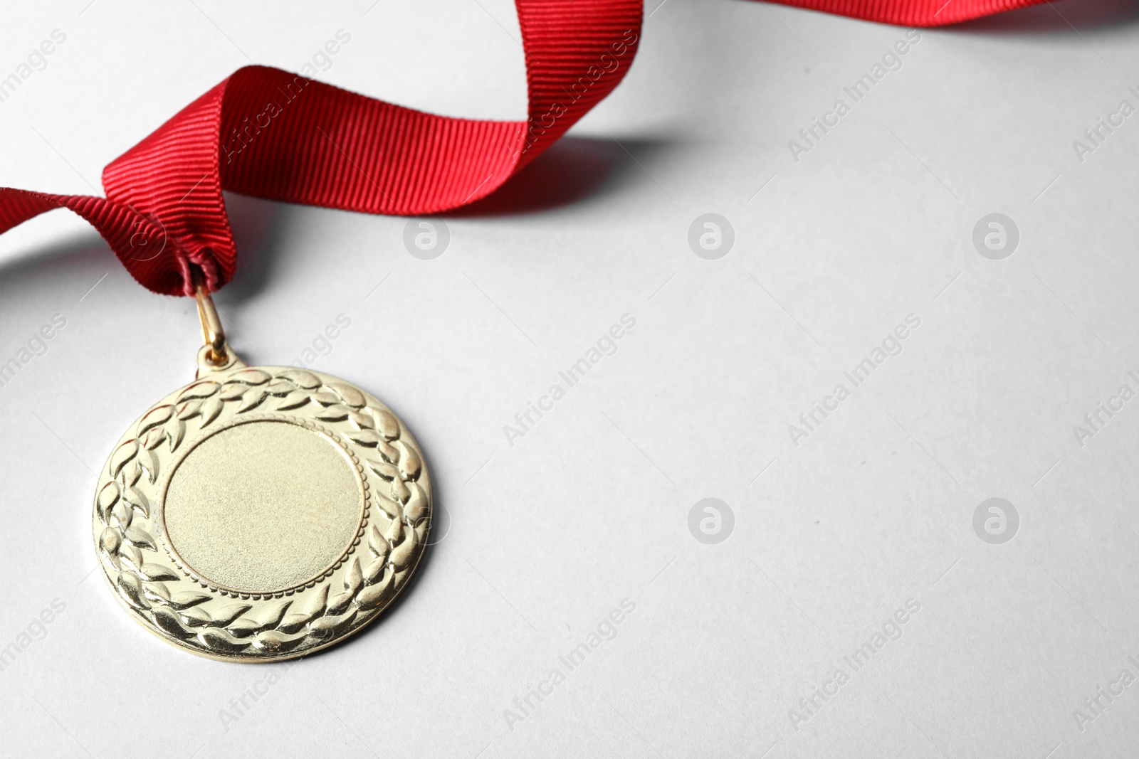 Photo of Gold medal with space for design on light background. Victory concept