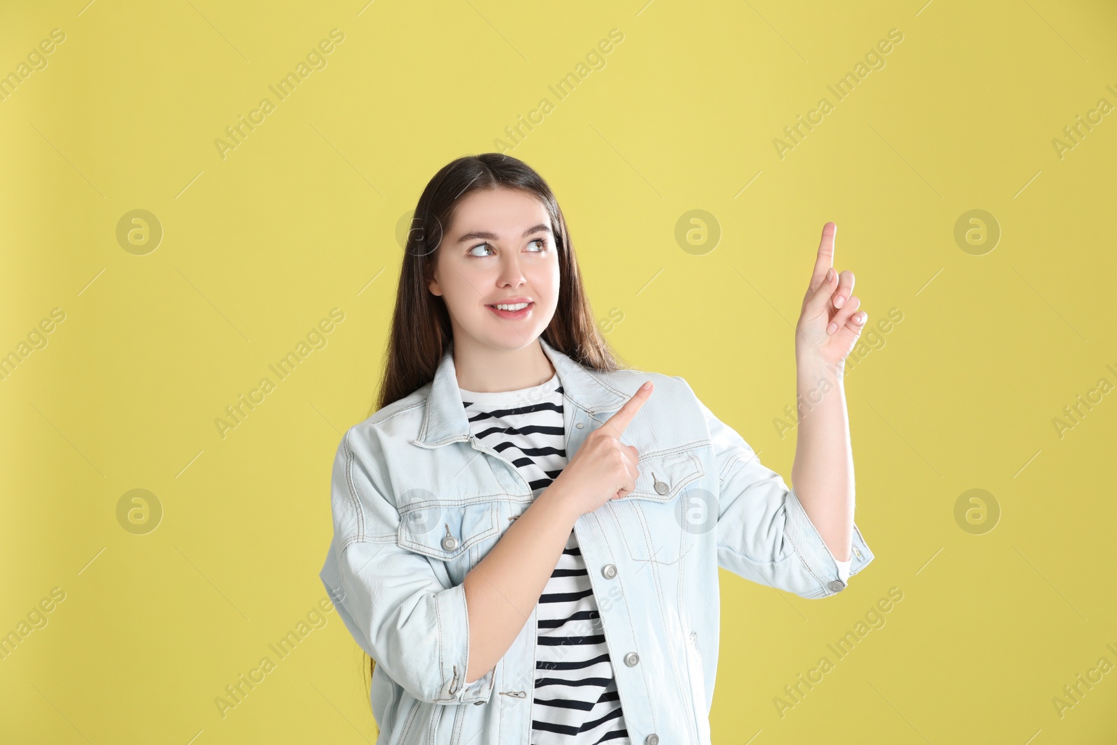 Photo of Portrait of young woman on yellow background