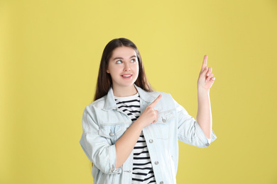 Portrait of young woman on yellow background