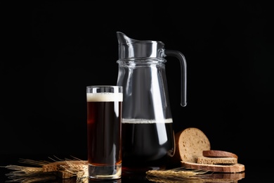 Delicious kvass, bread and spikes on black background