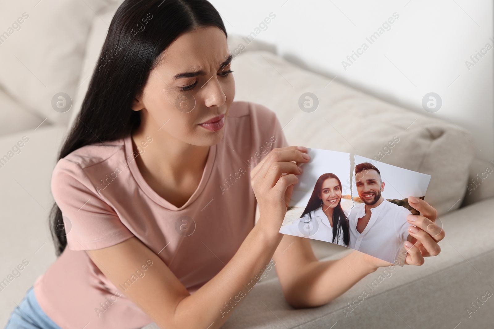 Photo of Upset woman ripping photo at home. Divorce concept