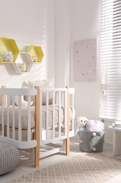 Hexagon shaped shelves on white wall in nursery. Interior design