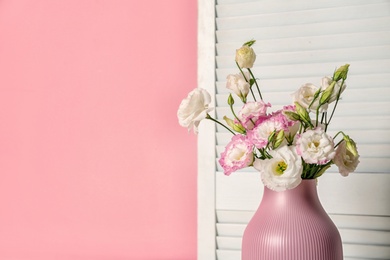 Photo of Beautiful flowers in vase and space for text on color background. Element of interior design