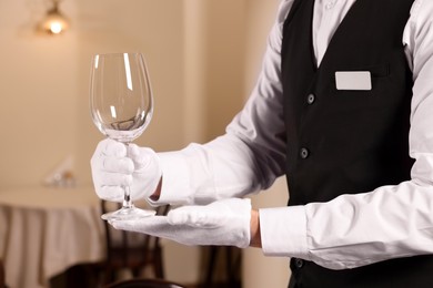 Man setting table in restaurant, closeup. Professional butler courses