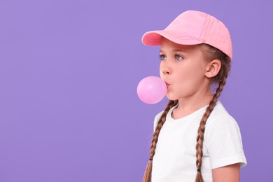 Photo of Girl blowing bubble gum on purple background, space for text