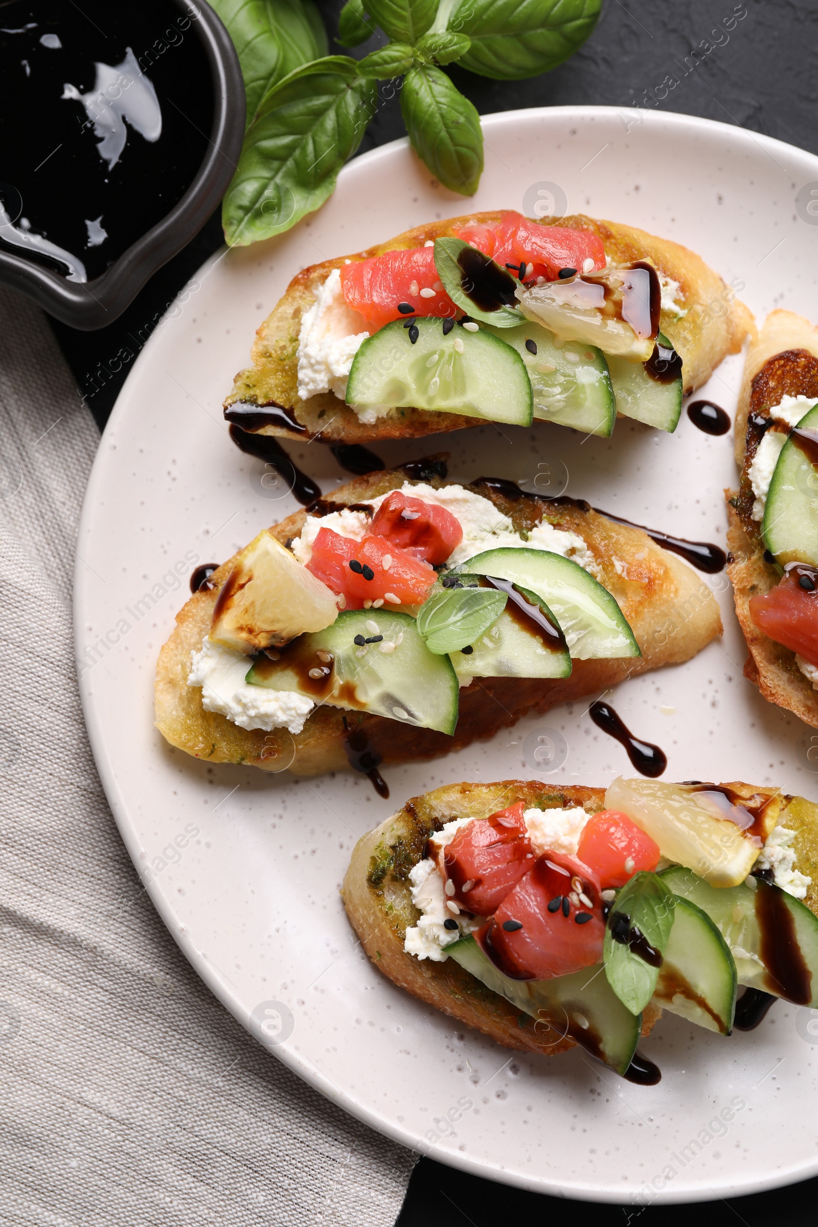 Photo of Delicious bruschettas with balsamic vinegar and toppings on table, flat lay