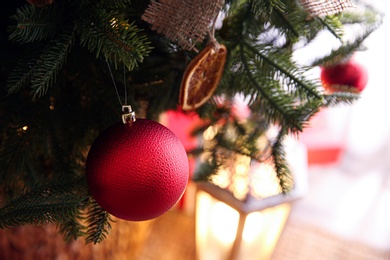 Beautiful Christmas tree decorated with festive lights and baubles indoors, closeup