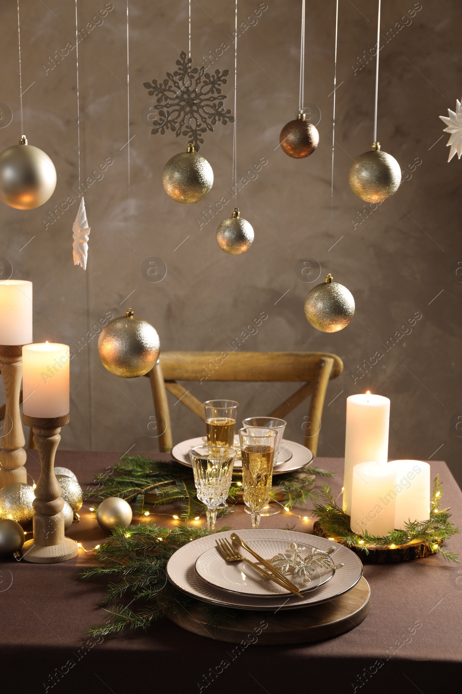 Photo of Christmas table setting with burning candles and festive decor