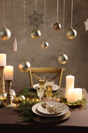 Photo of Christmas table setting with burning candles and festive decor