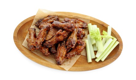 Photo of Wooden plate with delicious chicken wings and cut celery stalks isolated on white, top view
