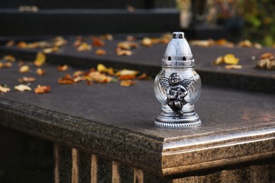 Photo of Grave lantern on granite surface in cemetery, space for text