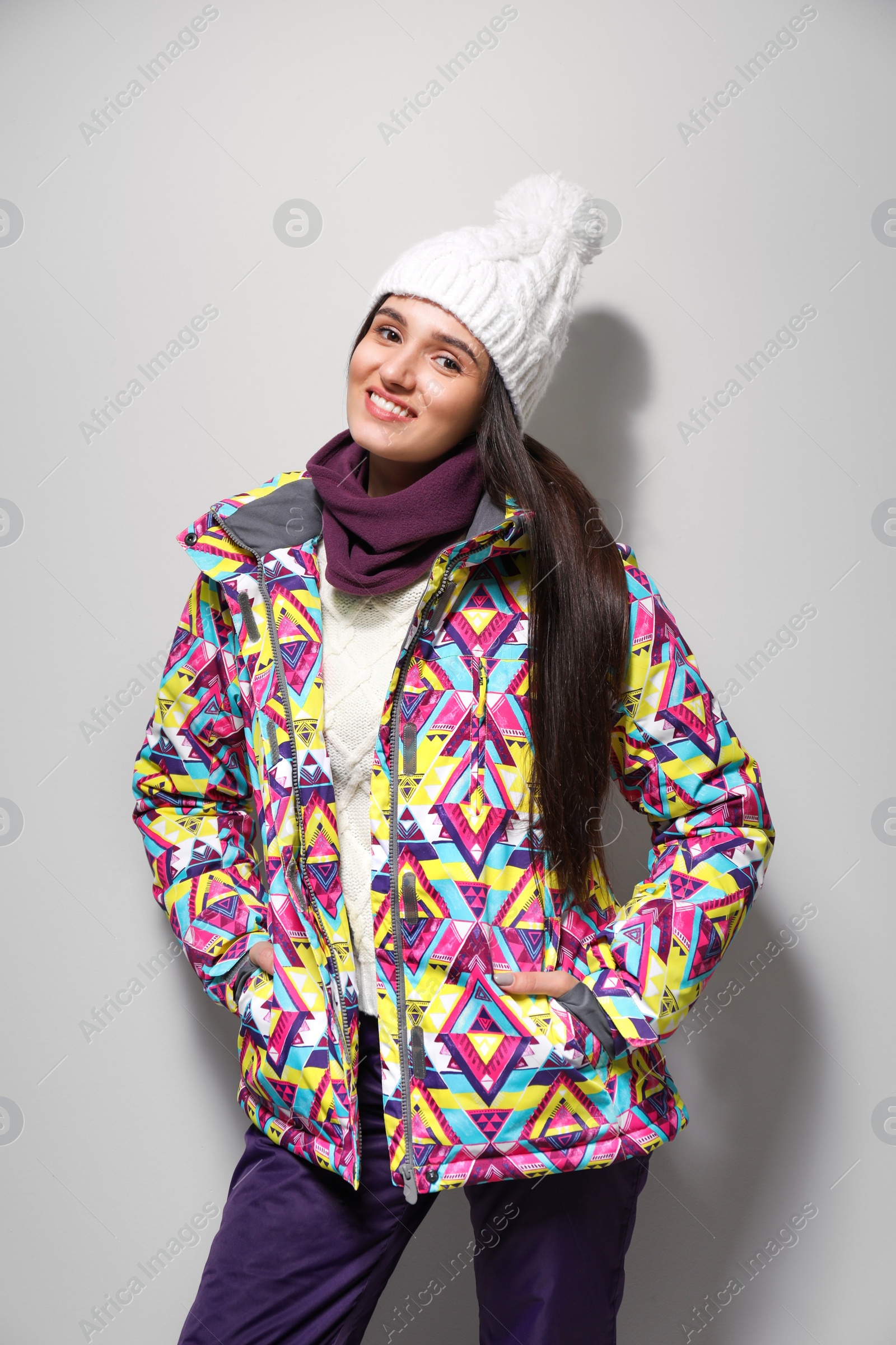 Photo of Woman wearing stylish winter sport clothes on light grey background