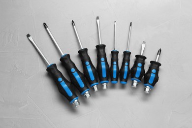 Set of screwdrivers on light grey background, flat lay