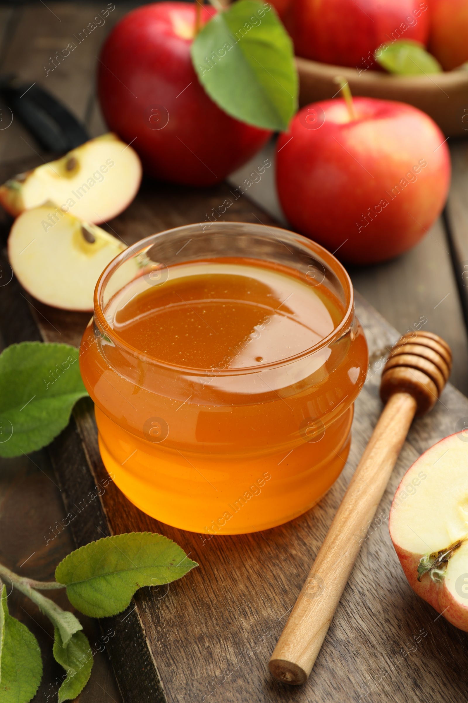 Photo of Sweet honey and fresh apples on wooden table