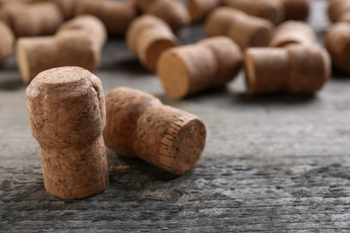 Photo of Sparkling wine bottle corks on wooden table, closeup