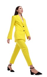 Photo of Beautiful businesswoman in yellow suit walking on white background