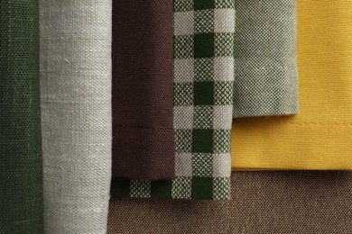 Photo of Many different fabrics on brown cloth, top view