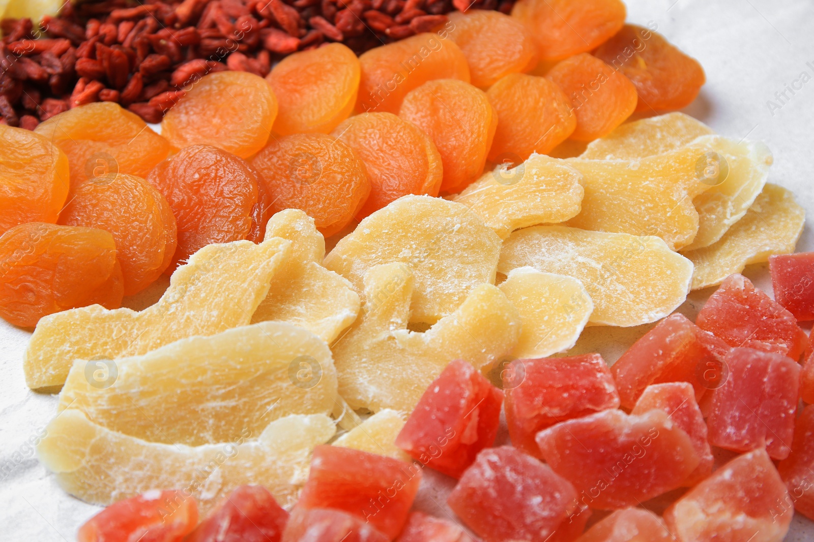 Photo of Different tasty dried fruits on paper, closeup