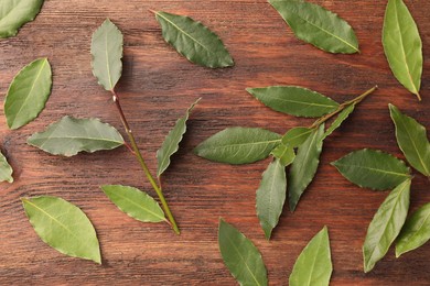 Photo of Aromatic fresh bay leaves on wooden table, flat lay