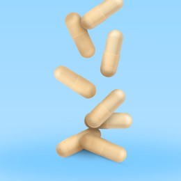 Image of Vitamin. Capsules falling on light blue gradient background