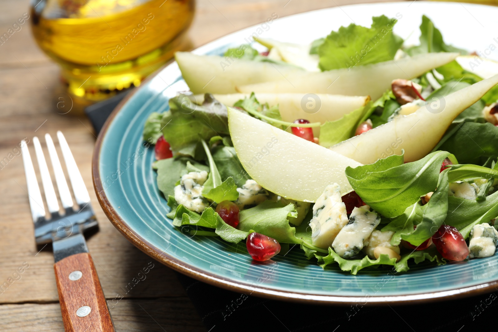 Photo of Fresh salad with pear served on wooden table