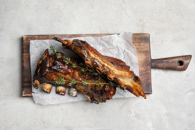 Photo of Delicious roasted ribs served on grey table, top view
