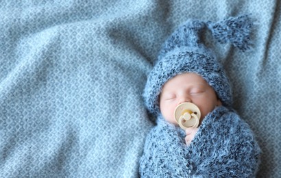 Cute newborn baby sleeping on blanket, top view