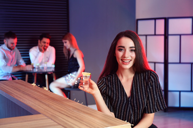 Young woman with Mexican Tequila shot at bar